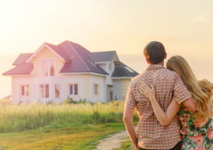Coppia di giovani di spalle che ammira una casa da sogno.